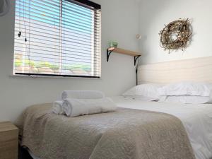 ein Schlafzimmer mit einem Bett mit zwei Handtüchern darauf in der Unterkunft 63 Whalerock Estate in Hermanus