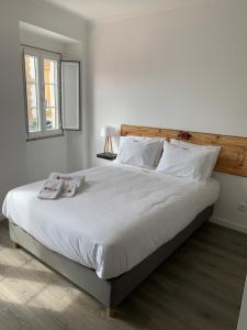 a bedroom with a large bed with white sheets and pillows at Alter Village Apartments in Alter do Chão