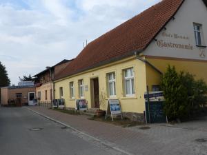 un edificio amarillo al lado de una calle en Ferienwohnung Olafs Werkstatt, en Neustadt