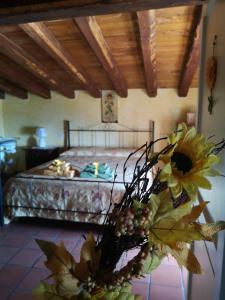 um quarto com uma cama e um vaso de flores em Centro Storico em Anagni