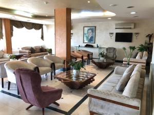 a living room with couches and chairs and a television at Dweik Hotel 2 in Aqaba