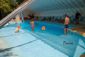 a group of people playing with balls in a swimming pool at La tricherie - maison d'hotes in Crastes +20 photos