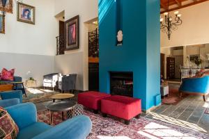 sala de estar con muebles de color azul y rojo y chimenea en 5th Avenue Gooseberry Guest House, en Johannesburgo