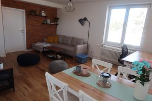 uma sala de estar com uma mesa e um sofá em Luxurious apartment 3 min walk to city center - snack, beverages included in price em Spišská Nová Ves