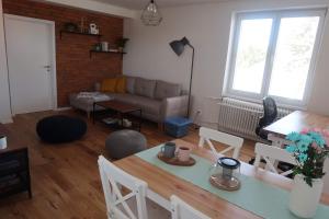 a living room with a table and a couch at Luxurious apartment 3 min walk to city center - snack, beverages included in price in Spišská Nová Ves