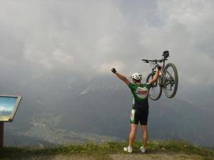 una persona sosteniendo una bicicleta en la cima de una montaña en Residence Kramhuter, en Sesto