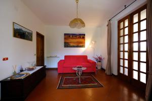 sala de estar con sofá rojo y mesa en Il Melograno - San Quirico d'Orcia, en San Quirico dʼOrcia