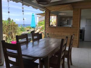 una mesa de madera y sillas en una cocina con vistas en Ocean île-heaven, en Le Moule