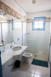 a bathroom with a toilet and a sink and a shower at Rafa's Pousada Encantos de Minas in Três Corações