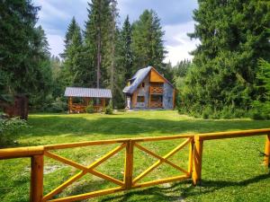 a wooden fence in front of a small house at Chata Tatry in Tatranska Strba