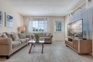 a living room with a couch and a flat screen tv at Foxtail in Siesta Key