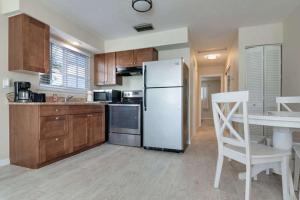 a kitchen with a white refrigerator and a table with a chair at Foxtail in Siesta Key