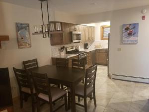 a kitchen with a table and chairs and a refrigerator at Ski In/Out Trailside Townhome in Killington