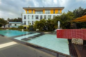 a building with a swimming pool and a water fountain at Red Mango Hotel and Apartments in Sekondi-Takoradi