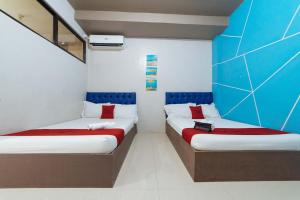 two beds in a room with blue and white walls at RedDoorz @ Aparente Gensan in General Santos +19 photos