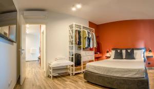 ein Schlafzimmer mit einem Bett und einer orangefarbenen Wand in der Unterkunft STELLA - Luxury by the Sea - Boutique Apartment in Martinsicuro