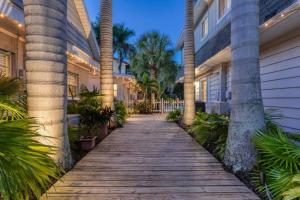 a walkway in front of a house with palm trees at Whitewood in Siesta Key