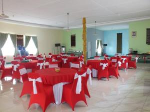 Habitación grande con mesas y sillas rojas y blancas. en GLOBAL VIEW HOTEL en Ende