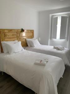 two white beds in a room with a window at Alter Village Apartments in Alter do Chão