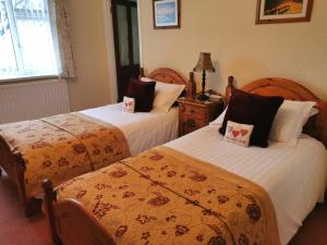 a hotel room with two beds and two lamps at Northumberland Cottage B&B in Eshott