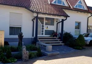 ein weißes Haus mit einer blauen Tür und einer Treppe in der Unterkunft Ferienwohnung Weiß Wachtenburg in Wachenheim an der Weinstraße