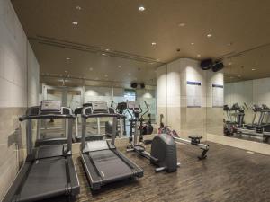 a gym with several tread machines and a mirror at APA Hotel & Resort Yokohama Bay Tower in Yokohama
