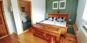 a bedroom with a wooden bed and a bathroom at Privathotel Der Schwarze Herrgott No TV in Zellertal