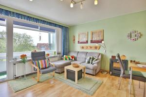 ein Wohnzimmer mit einem Sofa und einem Tisch in der Unterkunft Küstenoase in Cuxhaven