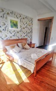 a large bed in a bedroom with a wooden floor at Privathotel Der Schwarze Herrgott No TV in Zellertal