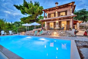 a villa with a swimming pool in front of a house at Villa Agapi in Athanion