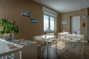 a dining room with two tables and chairs and a window at La Rosa Tra I Laghi B&B in Meina