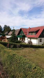 dom z czerwonym dachem na szczycie pola w obiekcie Landhausferienwohnungen Am Brockenblick w mieście Sorge