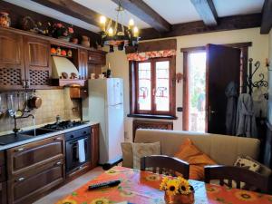 a kitchen with a table and a white refrigerator at La Chiave del Gufo - Castel di Sangro in Castel di Sangro