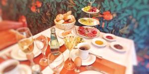 a table with plates of food and glasses of wine at Privathotel Der Schwarze Herrgott No TV in Zellertal