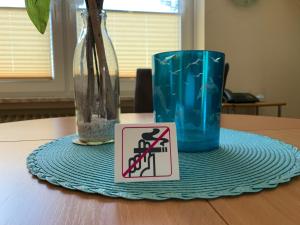 un cartello non fumatori e una tazza blu sul tavolo di Haus Gorch Fock a Neuharlingersiel