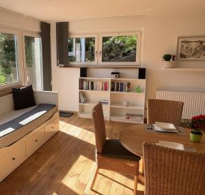 un soggiorno con tavolo, sedie e libreria di Ferienwohnung Drachennest mit Sonnenterrasse a Feldkirch