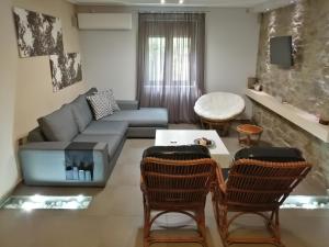 a living room with a couch and a table and chairs at Modern Residence in the Center of Trikala in Tríkala
