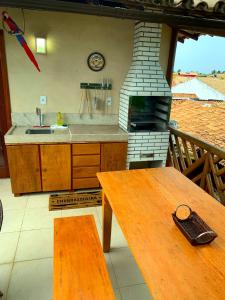 a kitchen with a stove and a wooden table at Duplex com hidromassagem - Praia do Forte in Praia do Forte