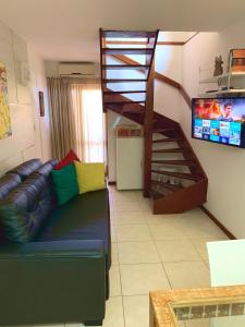 salon z kanapą i spiralnymi schodami w obiekcie Duplex com hidromassagem - Praia do Forte w mieście Praia do Forte
