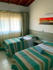 pokój hotelowy z 2 łóżkami i oknem w obiekcie Duplex com hidromassagem - Praia do Forte w mieście Praia do Forte