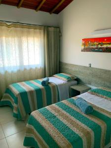 a hotel room with two beds and a window at Duplex com hidromassagem - Praia do Forte in Praia do Forte +19 photos