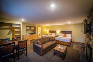 a hotel room with two beds and a couch at Alpine Inn & Suites in Nelson