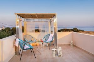 eine Terrasse mit Stühlen und einem Tisch auf dem Balkon in der Unterkunft Gennadi Serenity House- beachfront villa with pool in Gennadi