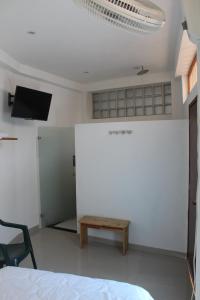 a room with a bed and a table and a tv at ATENEA SPA Hotel in Villeta