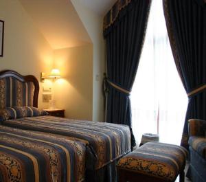 a hotel room with two beds and a window at Hotel De Borleña in Borleña