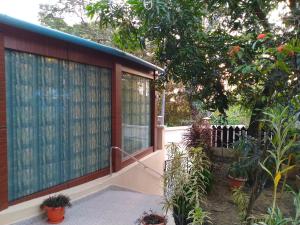 a house with a large window with plants at Kevins Homestay in Port Blair