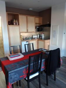 a kitchen with a table and chairs and a kitchen with at Gîte De La Ferme in Gundolsheim