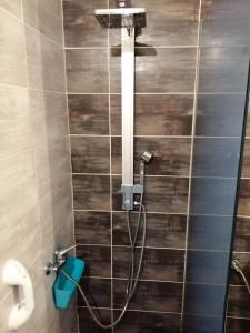 y baño con ducha y pared de madera. en Modern Residence in the Center of Trikala, en Tríkala