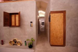 a hallway with a door and a plant in a room at Sante Commune Hostel Yogyakarta in Yogyakarta +40 photos