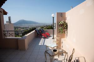 a balcony with chairs and a table on a building at COZY LOFT (studio) 360o VIEW OF ATHENS in Athens